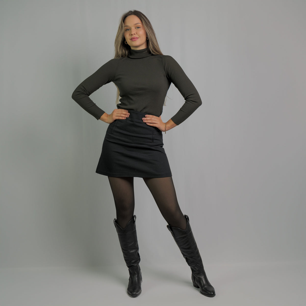 Collant polaire noir porté avec une jupe et des bottes